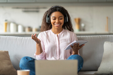 Smiling woman in headphones with laptop at home
