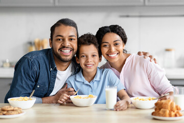 Happy African American family enjoying breakfast in kitchen