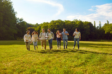 Group of happy young friends having fun outdoors in the summer. Seven cheerful, joyful men and...
