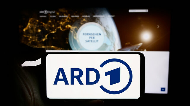 Stuttgart, Germany - 04-10-2024: Person holding cellphone with logo of German public-service broadcasting organisation ARD in front of webpage. Focus on phone display.
