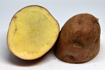 a cut of a potato tuber with black spots and streaks. The texture of a diseased potato tuber. Unsuitable for use in food and for planting. Selective focus. Dirty background