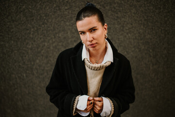 Portrait of a fashionable woman with piercings standing on street.