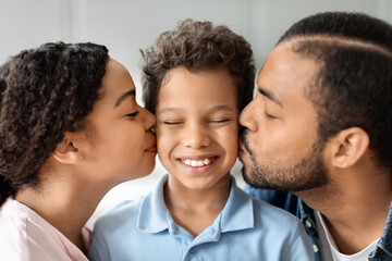 African American parents kissing happy child preteen bot