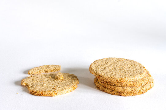 A stack of crumbly rough Oatcakes on a white backgrond.
