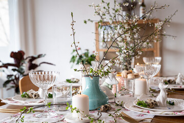 Spring Easter decor. Easter table setting. Flowers and dishes and candles for a festive dinner. 