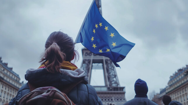 At the foot of an iconic monument, a woman leads a chorus of voices, the EU flag unfurling like a beacon of unity. Tourists and locals alike pause, captured by this timeless tablea
