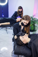 Permanent make-up of eyebrows. Woman professional permanent artist with a tool. A young permanent...