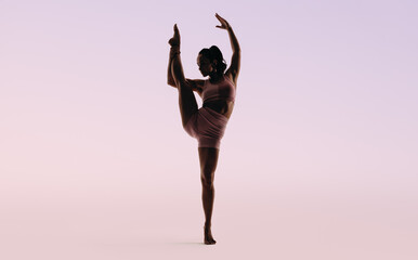Female gymnast performing an impressive one leg pose in a studio