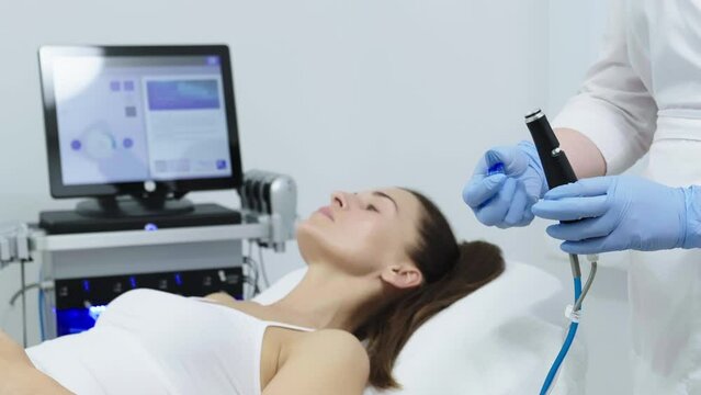 A doctor performs cosmetic procedures for rejuvenation and facial cleansing on a middle-aged patient in a cosmetology clinic. Hydropic cosmetic procedure, facial cleansing, clean skin.