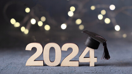 Class of 2024 concept. Number 2024 with graduation cap and bokeh lights.