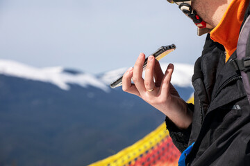 skier is talking on the phone on a snowy slope at a ski resort. Active recreation
