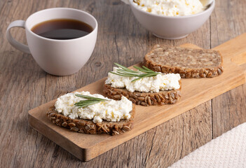 Homemade rye bread with cottage cheese in a plate and coffee. Healthy breakfast concept