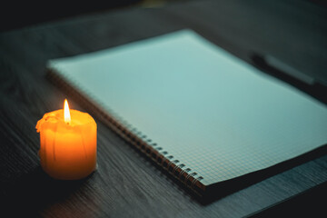 Large notebook and black marker in candlelight