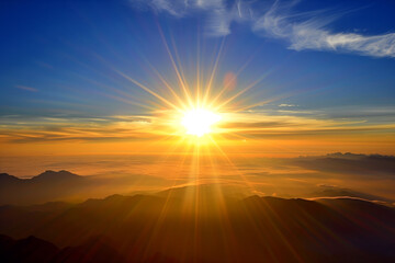 Breathtaking sunrise above the clouds, casting a golden hue over the silhouetted mountains