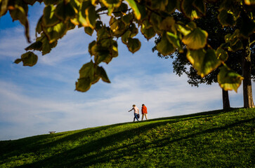 A couple stroll through a park in the city of Copenhagen.