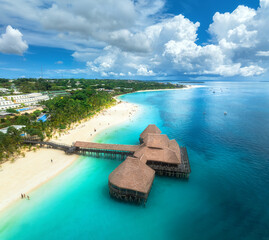 Aerial view of bungalow, white sandy beach, ocean on summer sunny day. Restaurant on the sea. Top...
