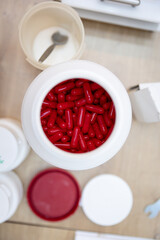 White container with red pills at the pharmacy health help making medicine drugs treatment healthcare
