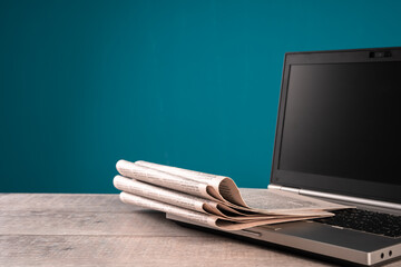 Newspapers on laptop, information, media concept, old and new sources of information