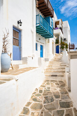 White houses in narrow alley of traditional Kastro village with palm tree in background, Sifnos island, Greece - 792072555
