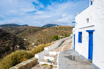 View of Kastro village buildings from coastal promenade with mountain ladscape in background, Sifnos island, Greece - 792073122