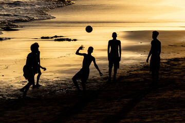 People play beach soccer during sunset on Ondina beach in Salvador, Bahia.