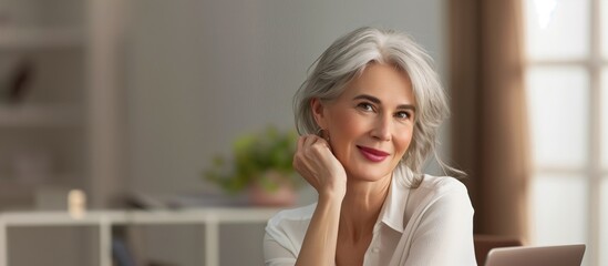 Fototapeta premium Confident Mature woman silver haired home office business laptop relaxed working from home.