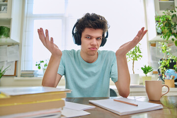 Webcam view of college student guy in headphones, talking looking at camera