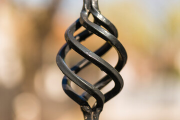 Part of a metal forged fence. Metal spiral ornament, detail from the fence