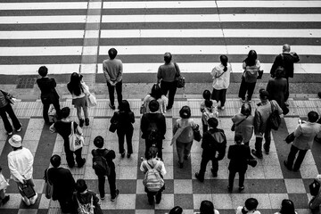 大阪梅田の繁華街で横断歩道で信号待ちをする人々。モノクロで撮影