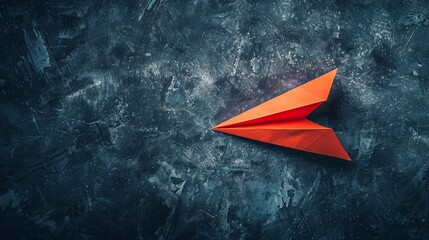 Red origami paper plane on a textured blue background.