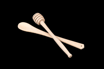 Wooden spoons and honey on a black background, wood, handmade