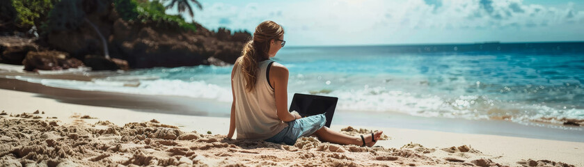 girl sitting on beach sand using laptop