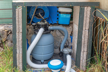 Pool equipment with filtration system and pump in yard for clean swimming water.
