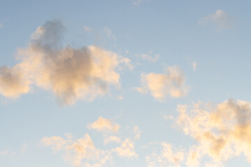 close up of ethereal clouds at twilight with yellow tint against a beautiful blue sky