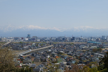 Fototapeta premium 満開の桜春霞の薬師岳北アルプス立山連峰と神通大橋