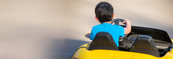 the kid driving the little yellow car in the city. stock photo