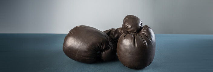 black boxing gloves, studio settings, sports concept stock photo, blue, gray background