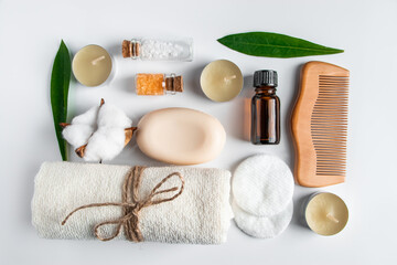 Set of natural cosmetics and spa accessories on white background. Towel, soap, hairbrush, essential oil.