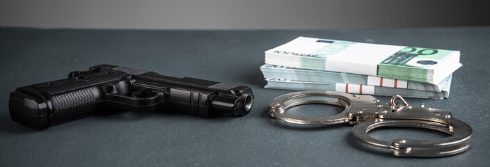 Gun, handcuffs and money on black background, stock photo, criminal concept