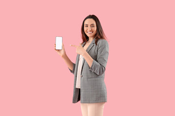 Pretty young woman with smartphone on pink background