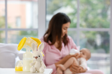 Breast pump with toy on table in bedroom, closeup