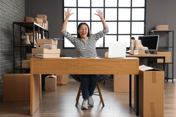 Happy Asian seller working at table in warehouse store