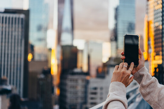 A person takes a mobile photo of the Manhattan skyline in New York City, United States.