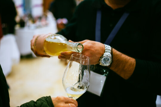 Sommelier pouring wine for wine tasting in a bar of restaurant or wine expo.