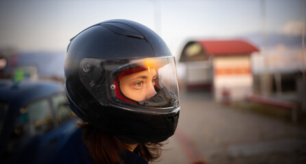 woman in helmet motorcyclist at sunset close-up