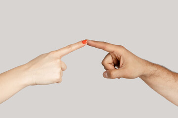 Closeup of woman and man opposed hands pointing touching at each other wit index fingers. Indoor...