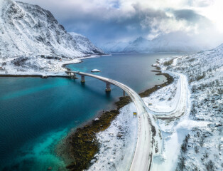 Aerial view of bridge over the sea and snowy mountains in winter