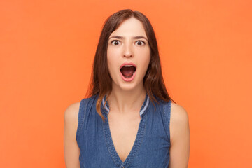 Portrait of amazed shocked surprised brunette woman looking at camera with big eyes and open mouth,...