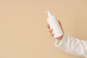 Woman holding bottle of natural cream on color background, closeup