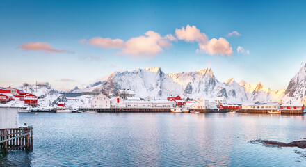 Astonishing winter view on Hamnoy village with port and snowy  mountain peaks  on background.